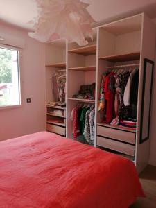 索尔特奥瑟戈尔Superbe appartement face au lac d'Hossegor的一间卧室配有一张红色的床和一个衣柜