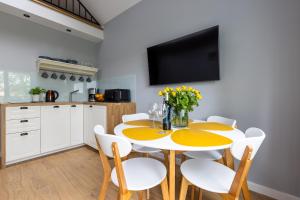 韦巴Apartamenty na wydmach的厨房以及带黄色桌椅的用餐室。
