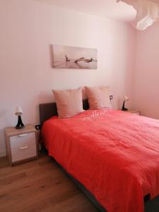 索尔特奥瑟戈尔Superbe appartement face au lac d'Hossegor的一间卧室配有红色的床和两个枕头