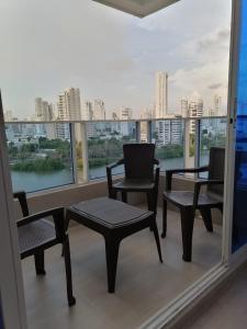 卡塔赫纳Ocean blue Ed Conquistador的阳台配有桌椅,享有城市美景。