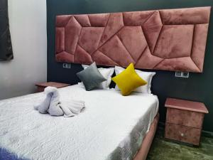 Tan-Tan Plage春分露营地旅馆的一间卧室配有一张大床和一个大软垫床头板