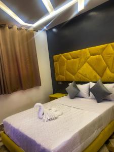 Tan-Tan Plage春分露营地旅馆的一间卧室配有一张带黄色床头板的大床
