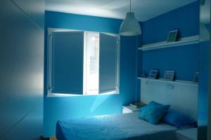 奥莱罗斯Piso en Santa Cristina, a 150 m de la playa的蓝色的卧室设有床和窗户