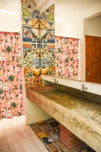 卡塔赫纳Casa Del Pozo Boutique Hostel的浴室的墙壁上铺有色彩缤纷的瓷砖。