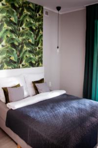 比得哥什Apartamenty Długa 6的卧室配有一张带大型叶壁画的床。