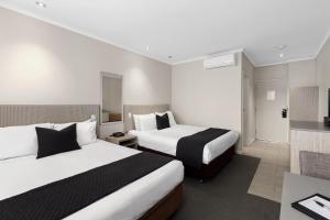芒特甘比尔The Commodore的酒店客房设有两张床和电视。