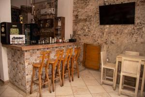 卡塔赫纳Casa Zahri Boutique Hostel的吧台上摆放着一排木椅的酒吧