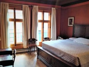 魁北克市L管理酒店的一间卧室设有一张床和两个窗户。