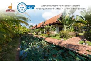 蔻立Khaolak Bhandari Resort & Spa - SHA Extra Plus的房屋前带池塘的花园