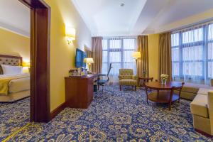 阿拉木图Ramada by Wyndham Almaty的酒店客房设有床和客厅。