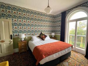 奥玛鲁Casa Nova House的一间卧室配有一张带花卉壁纸的床
