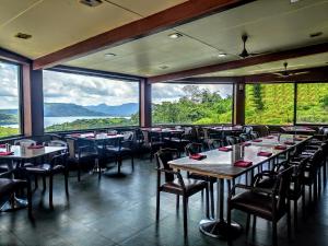 罗纳瓦拉顶层平台度假村的餐厅设有桌椅和大窗户。