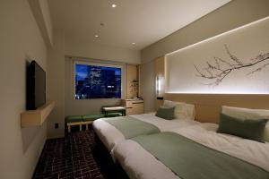 东京Hotel Yaenomidori Tokyo的酒店客房设有床和窗户。