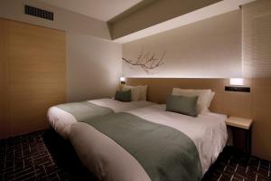 东京Hotel Yaenomidori Tokyo的一间卧室配有一张大床和两个枕头