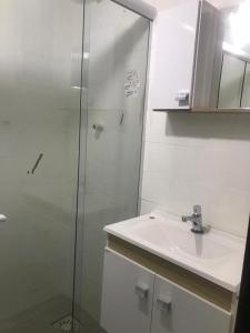 马卡埃LOFT aconchegante no Centro de Macaé, Wifi, Ar condicionado e Cozinha completa的一间带水槽和玻璃淋浴的浴室