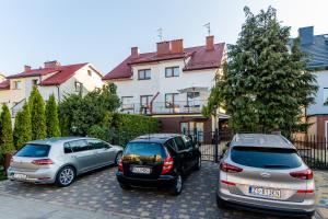 科沃布热格Pokoje goscinne的三辆车停在房子前面的停车场