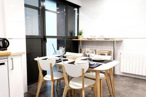 毕尔巴鄂Dolaretxe apartment by People Rentals的一间带桌子和白色椅子的用餐室