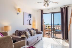 美洲海滩Tenerife South Apartments的带沙发的客厅,享有海景