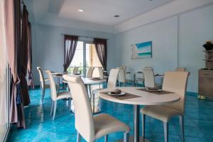 圣伊西多罗Residenza Del Mare的一间设有白色桌椅的用餐室