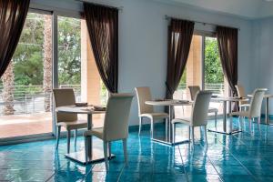 圣伊西多罗Residenza Del Mare的一间带桌椅的用餐室和大窗户