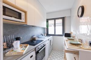 雷凯蒂奥Agirre - BasKey rentals的白色的厨房配有水槽和微波炉