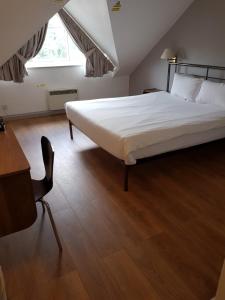 奥尔德姆247酒店.com的一间卧室设有一张大床,铺有木地板