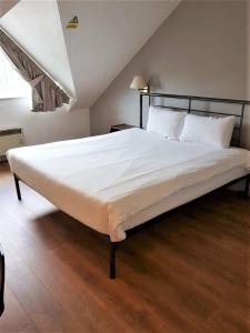 奥尔德姆247酒店.com的一间卧室配有一张带白色床单的大床