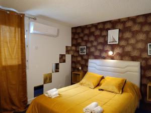 罗莫朗坦Astrotel Romorantin-Lanthenay Soirée étape的一间卧室配有黄色的床和毛巾