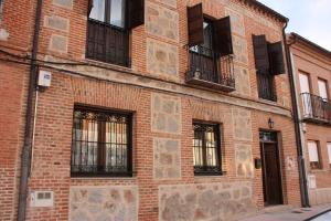 贝拉约斯Casa Rural Puerta de Castilla的一座砖砌建筑,设有窗户和阳台