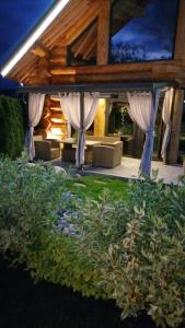巴尼亚Alpina Luxury Chalets的户外庭院配有白色窗帘和沙发