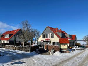 格赫伦-莱宾弗里森希度假村的雪 ⁇ 街道上一座有红色屋顶的房子