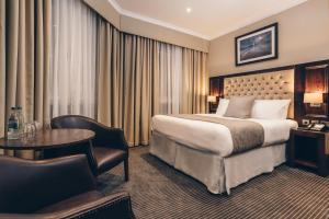 泰恩河畔纽卡斯尔County Hotel & County Aparthotel Newcastle的酒店客房配有一张床铺和一张桌子。