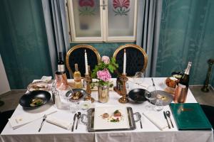 斯玛杰克托莱塞Dvorec Gregorčič的一张桌子,上面有白色的桌布和葡萄酒瓶