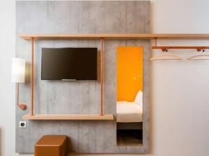 沙勒罗瓦沙勒罗瓦机场宜必思快捷酒店 的一间墙上配有电视的房间