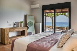 希伊Alekos Beach Houses-Eternity的一间卧室配有一张床,享有海景