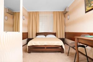尼古拉耶夫Green City Hotel的一间卧室配有一张床、一张桌子和一张书桌