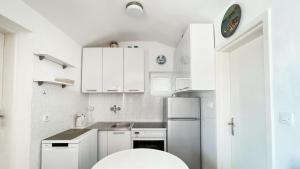 斯韦蒂·斯特凡Apartments Antonela的白色的厨房配有白色橱柜和水槽
