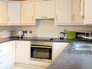 邓甘嫩Luxurious KC House的厨房配有白色橱柜和炉灶烤箱。