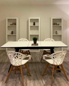 卡里翁德洛斯孔德斯Hostal Comfort Suites的一间配备有白色桌椅的用餐室