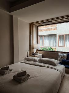 清迈NORN Nimman13 Boutique Hotel Chiang Mai的一间卧室配有一张大床和两条毛巾