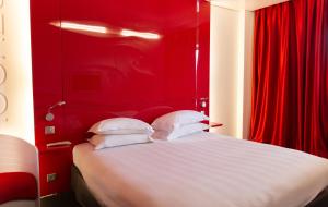 拉特斯特德布赫Zenitude Hôtel Résidences Bassin d'Arcachon的红色卧室配有带白色枕头的床