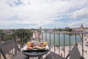 拉罗谢尔Tour de Nesle La Rochelle Vieux Port 3 etoiles的阳台上的餐桌,享有水景