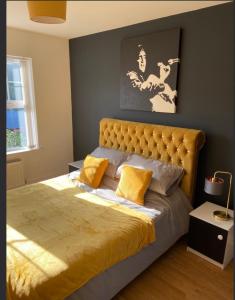 班戈北爱尔兰A Bigger Splash -Apartment Bangor West的一间卧室配有一张带黄色枕头的大床