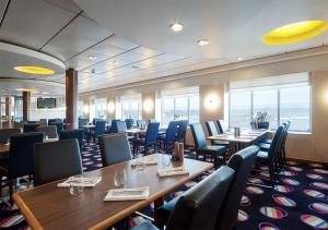 赫尔辛基Viking Line ferry Viking XPRS - Night Cruise from Helsinki的餐厅内带桌椅的用餐室