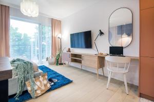 科沙林W&K Apartments - Joy Suite的一间卧室配有书桌、电视和镜子