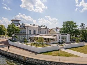 哈普萨卢Villa Friedheim的水体旁的白色大建筑