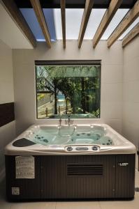 波尔多·格尼拉无限度假村的一个带窗户的客房内的按摩浴缸