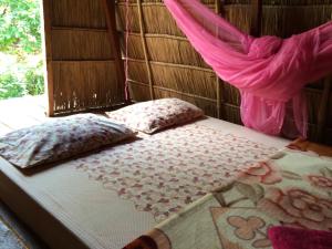 森莫诺隆Tree Lodge的配有枕头和窗户的客房内的一张床位