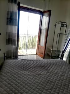 特拉比亚Benvenuti al Sud的一间卧室设有一张床和一个大窗户