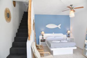 卢特拉NEFELI SUITES KYTHNOS的一间卧室设有一张床,楼梯拥有蓝色的墙壁